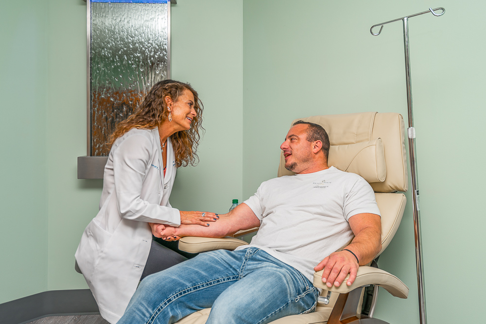 Dr. Paula administering IV therapy to a male patient.