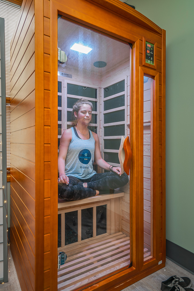 A woman sitting in a Sunlighten Infrared Sauna.