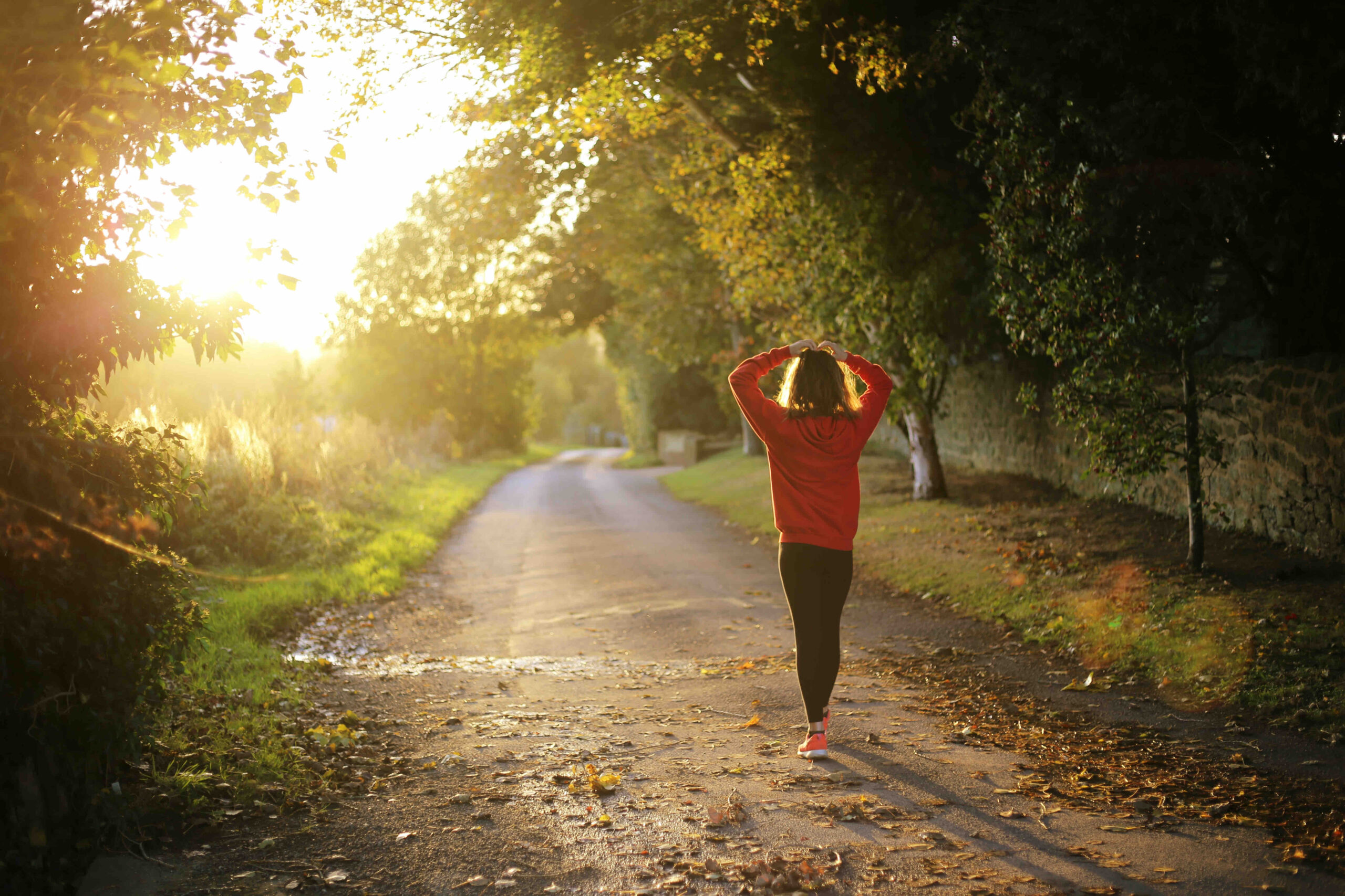 A woman taking a wellness walk in the sunshine.