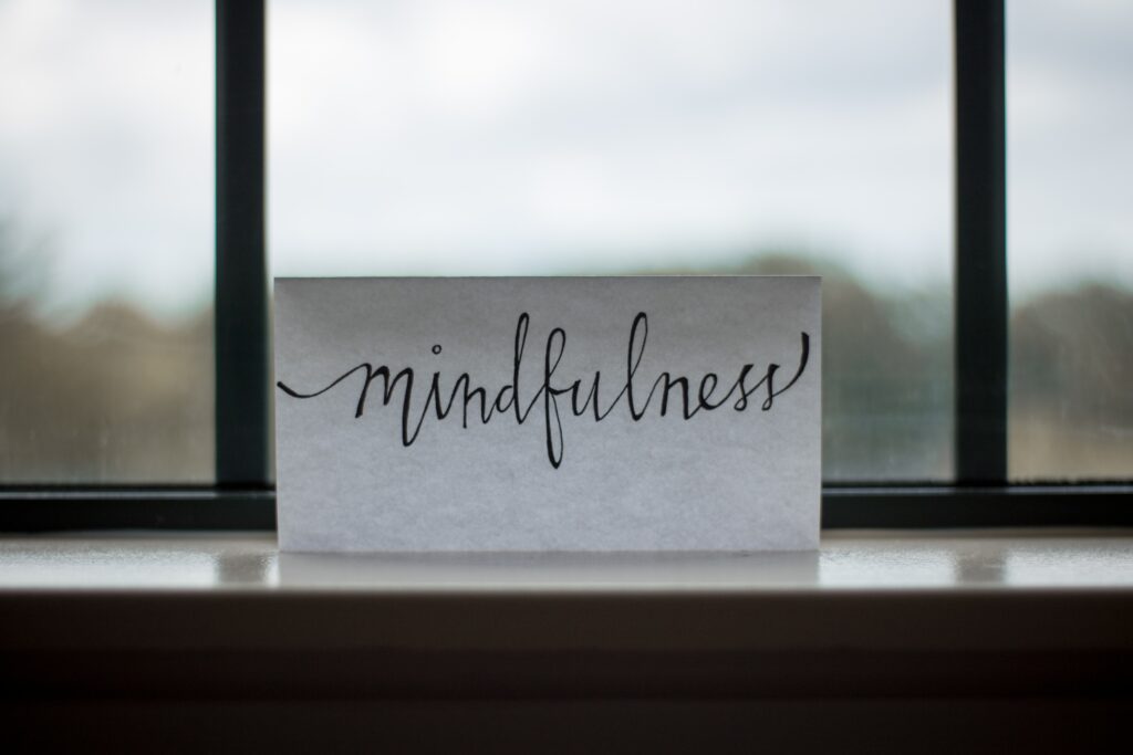 The word "mindfulness" written in calligraphy on a note in a window. 