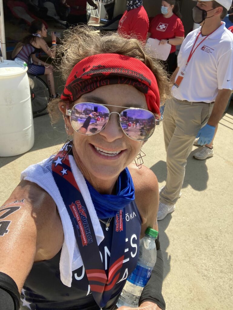 Paula Jones smiling and wearing purple sunglasses in her race gear after qualifying for Team USA.