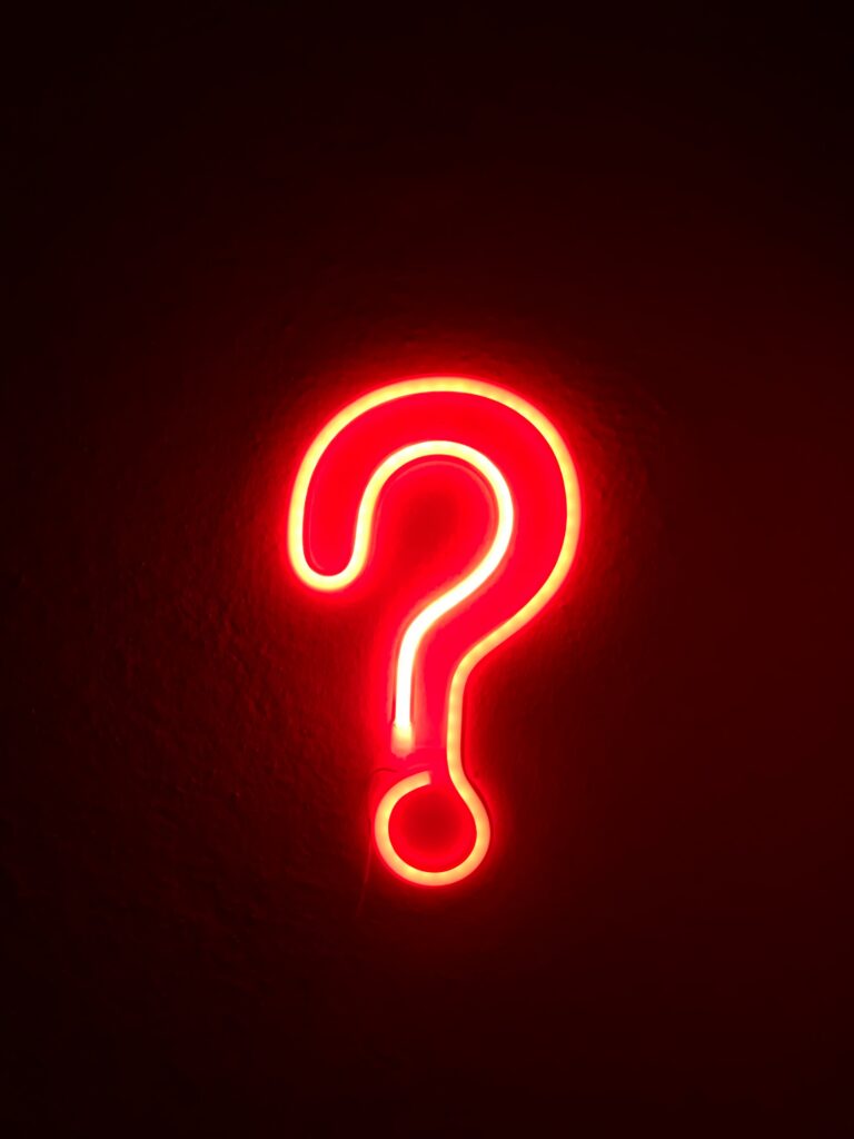 A red light in the shape of a question mark glows against a dark background.