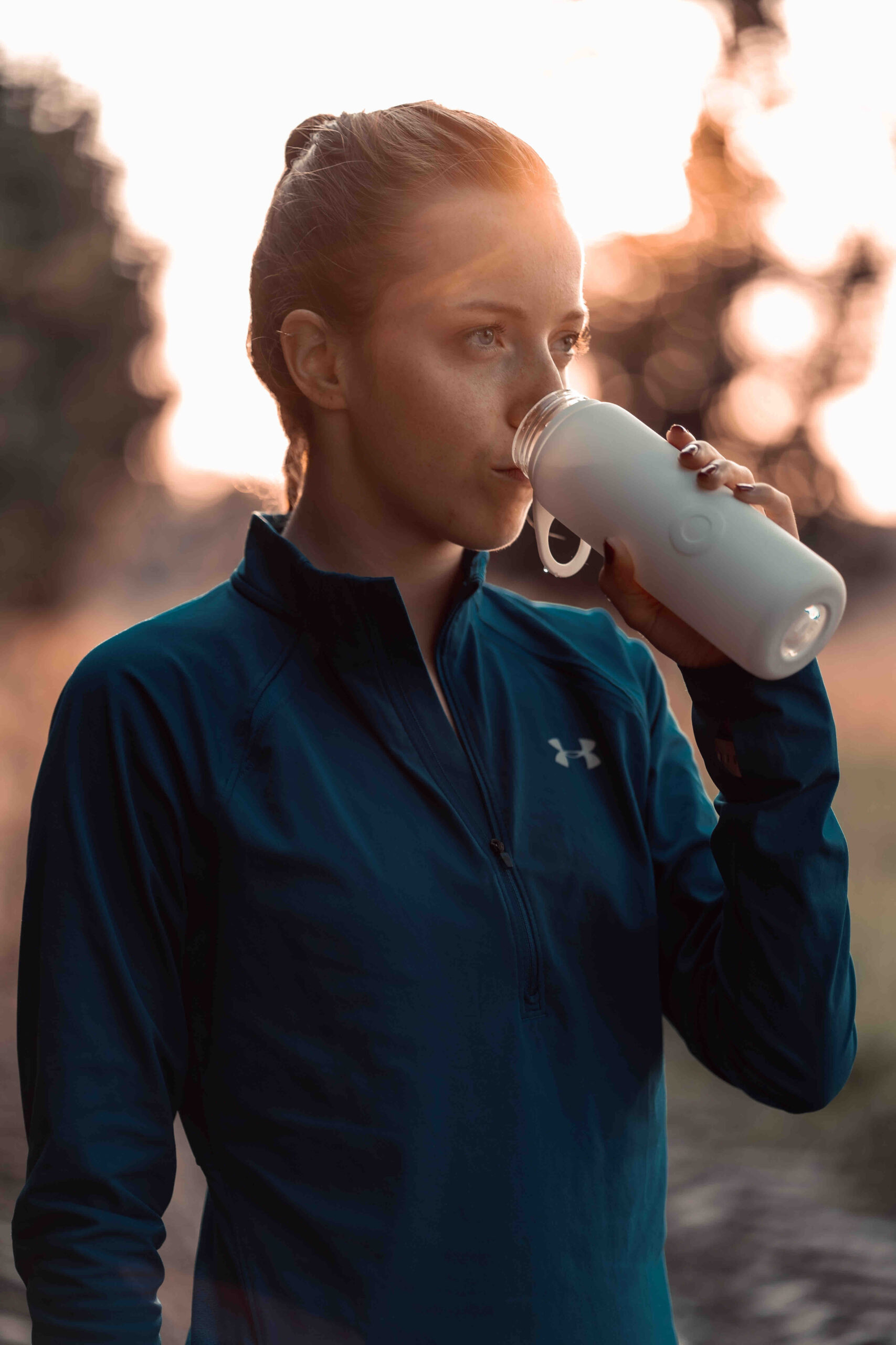 A female athlete drinking water.