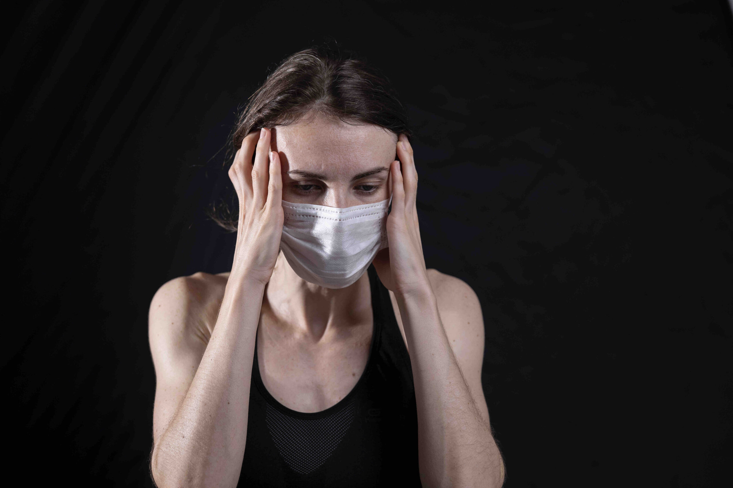 A woman looking worried in a COVID-19 mask.