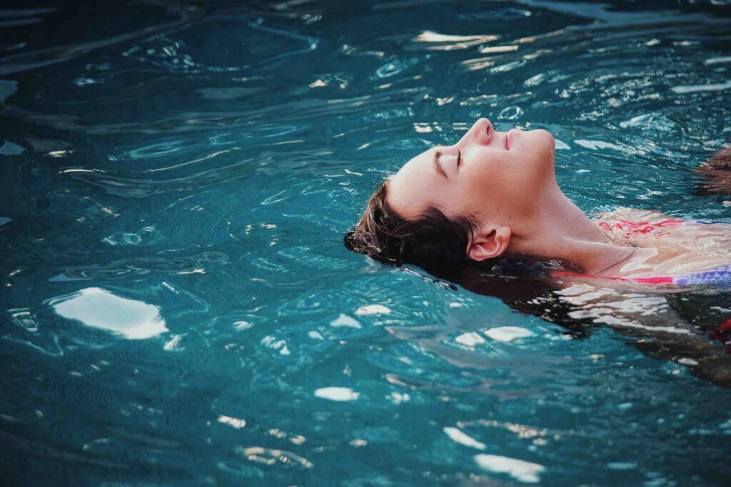 A woman doing backstroke as a fun stress-relieving activity.