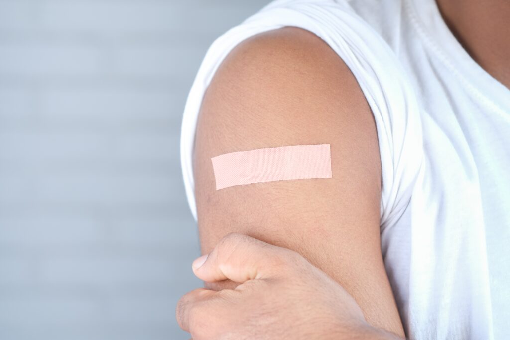 A Band-Aid on a man's shoulder following a vitamin D injections.