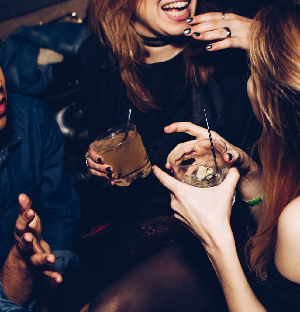 Women drinking dehydrating mixed drinks at a club.