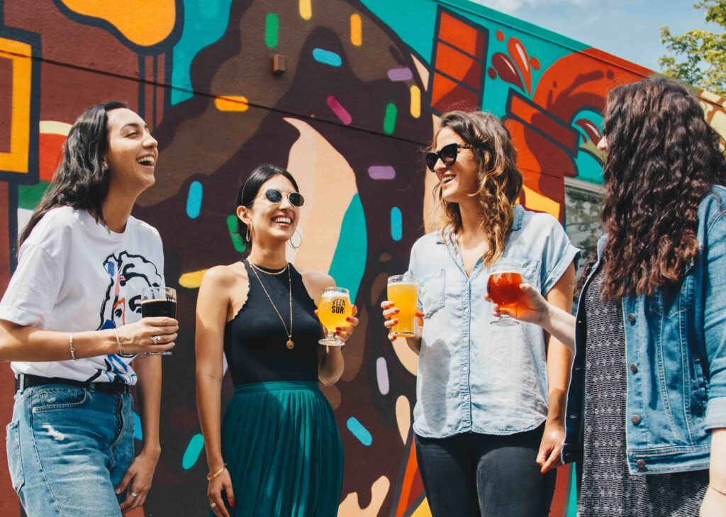 A group of ladies sipping on drinks and socializing outside of work.